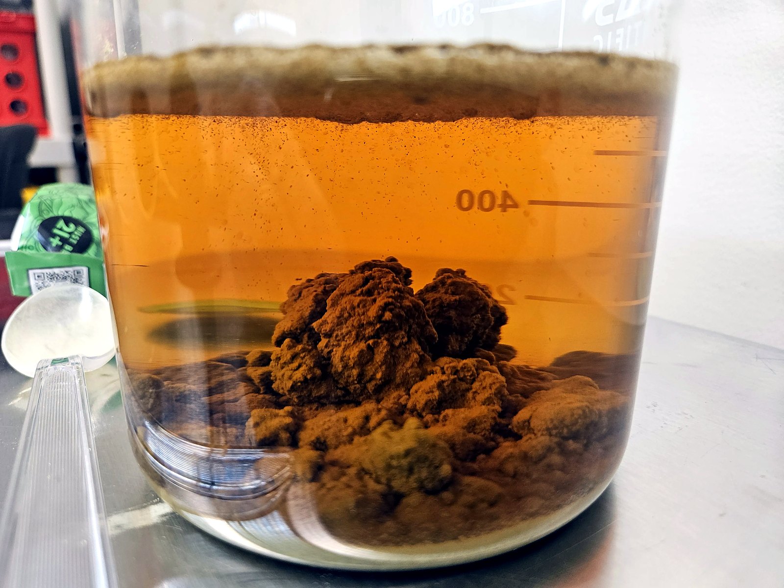 After sitting overnight, kratom powder settled into a rocky clumped bed at the bottom with clear amber liquid above.