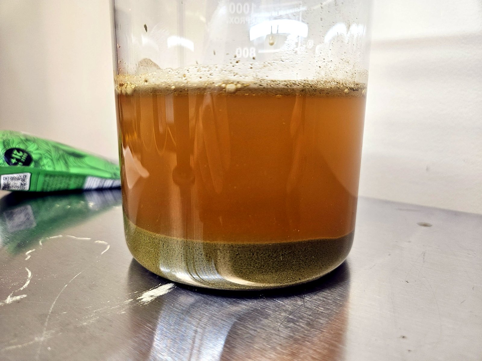 One hour after stirring, the kratom has settled again into a green bed beneath reddish-amber liquid.
